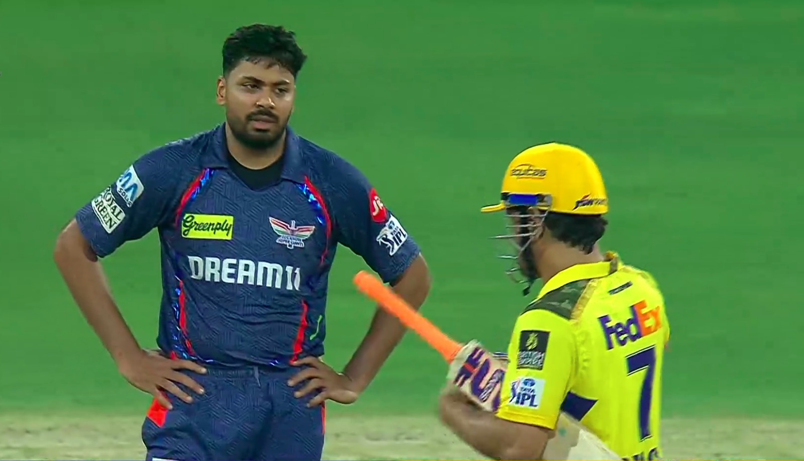 Dhoni with his bat on ground and avesh khan stand there